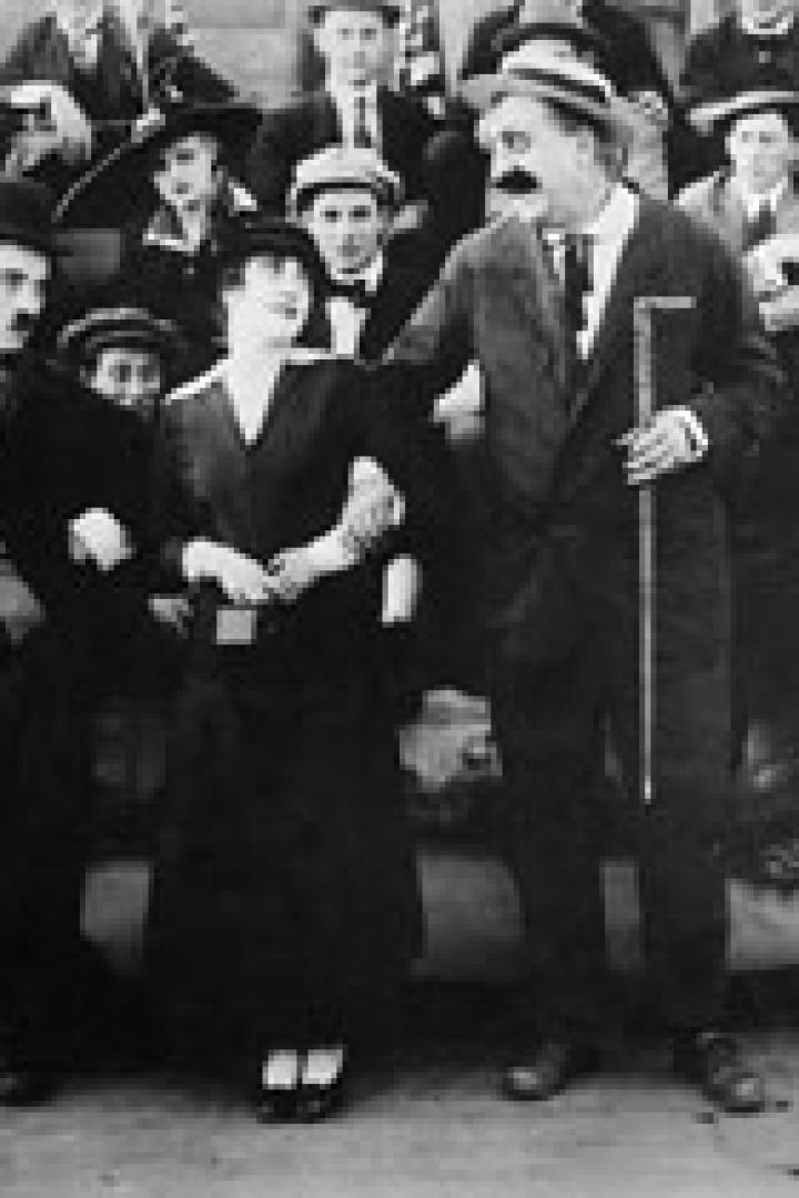 Eine Schwarzweißaufnahme von Charlie Chaplin mit Schauspielkollegen.