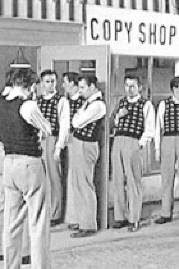 Eine Gruppe von Männern steht vor einem Copy Shop.