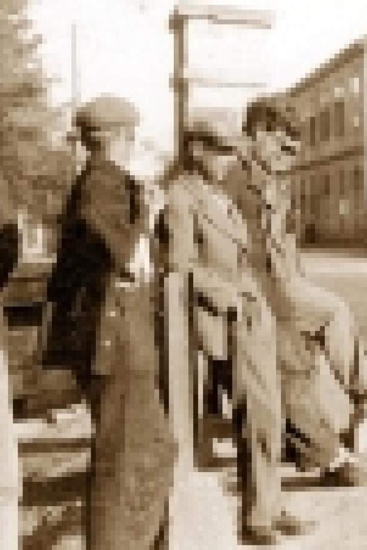 Eine Gruppe von Männern steht und sitzt an einer Straße in einer Stadt.