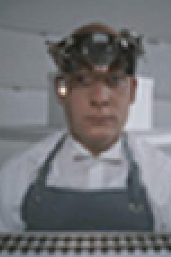 Ein Mann mit einer Apparatur auf dem Kopf schaut in die Kamera.