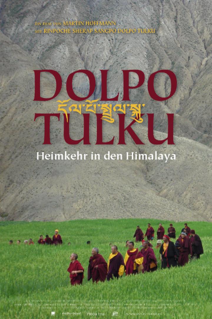Das Filmplakat für „Dolpo Tulku: Heimkehr in den Himalaya“ zeigt eine Gruppe Mönche in einem grünen Feld vor einer Bergkulisse.