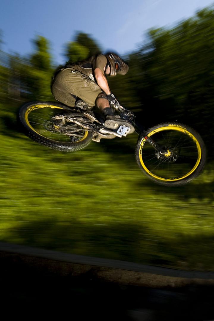 Ein Mountainbiker springt mit seinem Fahrrad über eine Rampe.