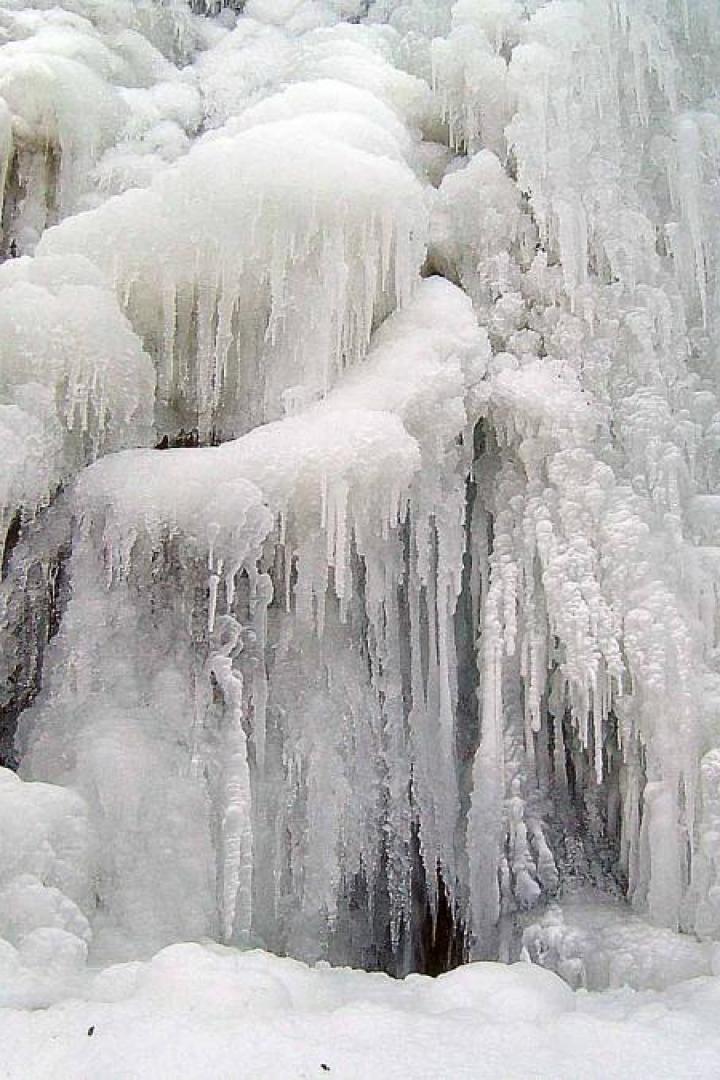Ein zugefrorener Wasserfall mit dicken Eiszapfen.