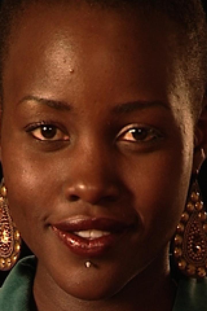 Nahaufnahme von Lupita Nyong'o mit goldenen Ohrringen und einem Piercing unter der Lippe.