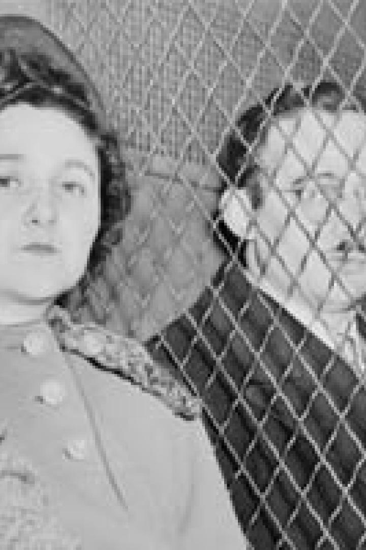 Ethel und Julius Rosenberg sitzen hinter einem Maschendrahtzaun.
