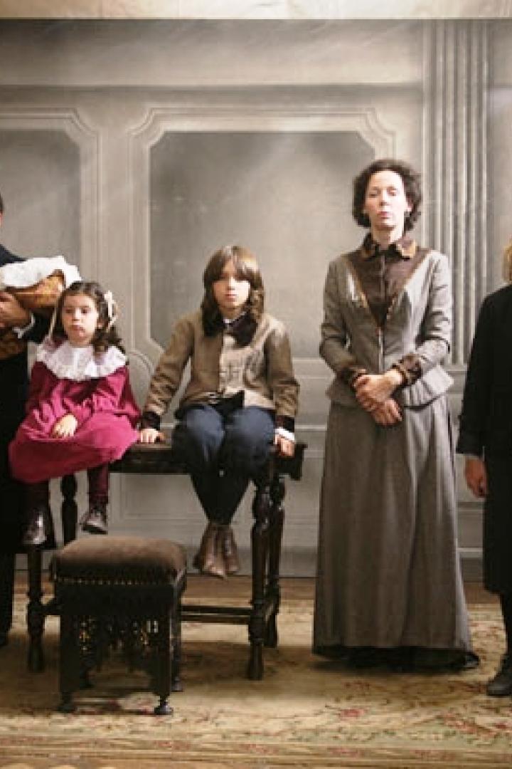 Eine formelle Familienaufnahme in historischer Kleidung in einem eleganten Raum.
