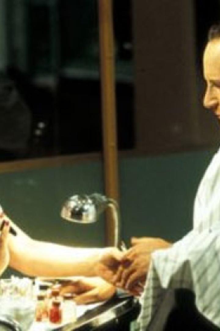 Eine Frau lackiert die Fingernägel eines Mannes.