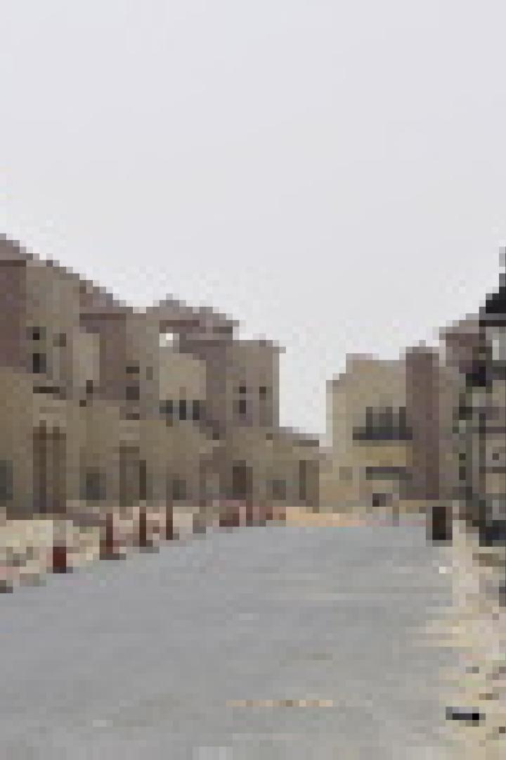 Eine Wohnstraße mit Häusern im mediterranen Stil und rot-weißen Leitkegeln.