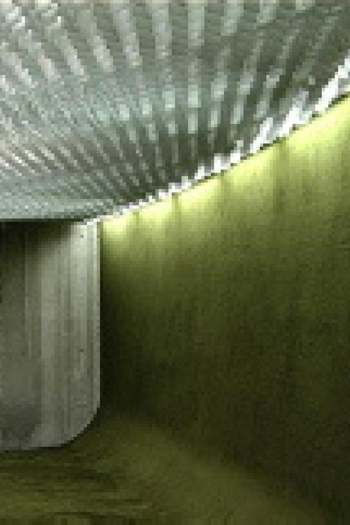 Innenansicht eines Tunnels mit einer strukturierten Decke und beleuchteten Wänden.