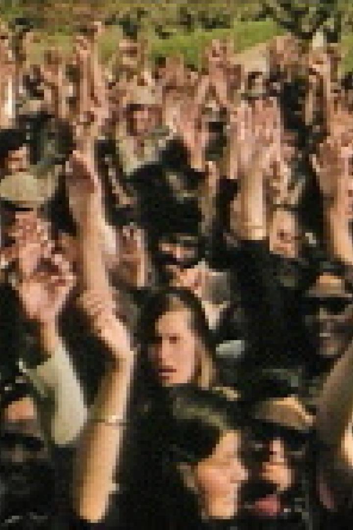 Eine große Menschenmenge jubelt mit erhobenen Händen.