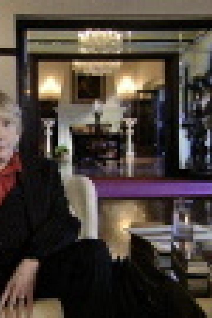 Eine Frau sitzt in einem eleganten Raum auf einem Sofa.