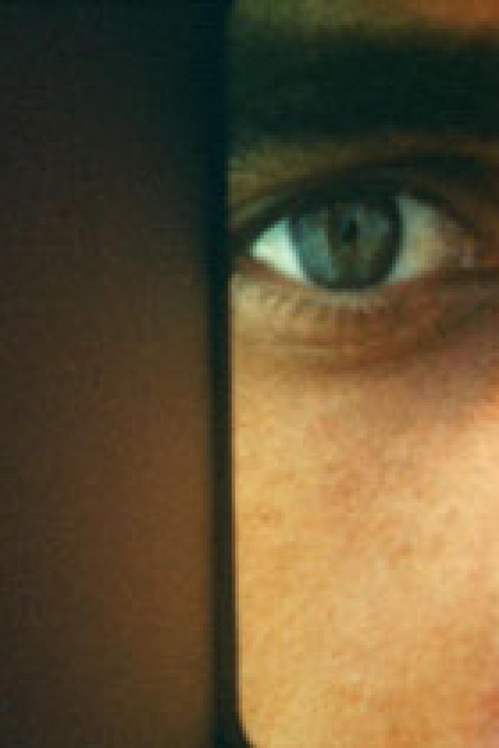 Nahaufnahme eines menschlichen Gesichts mit einem grünen Auge.