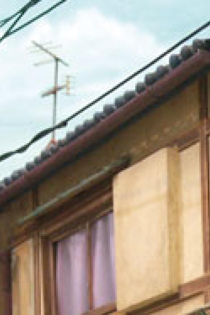 Ein Elektriker klettert auf einen Strommast in einer japanischen Stadt.