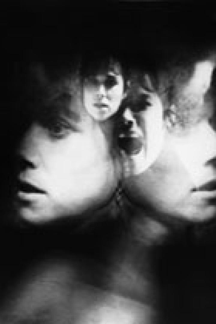 Ein Schwarz-Weiß-Foto zeigt mehrere überlagerte Gesichter mit ängstlichen Gesichtsausdrücken.