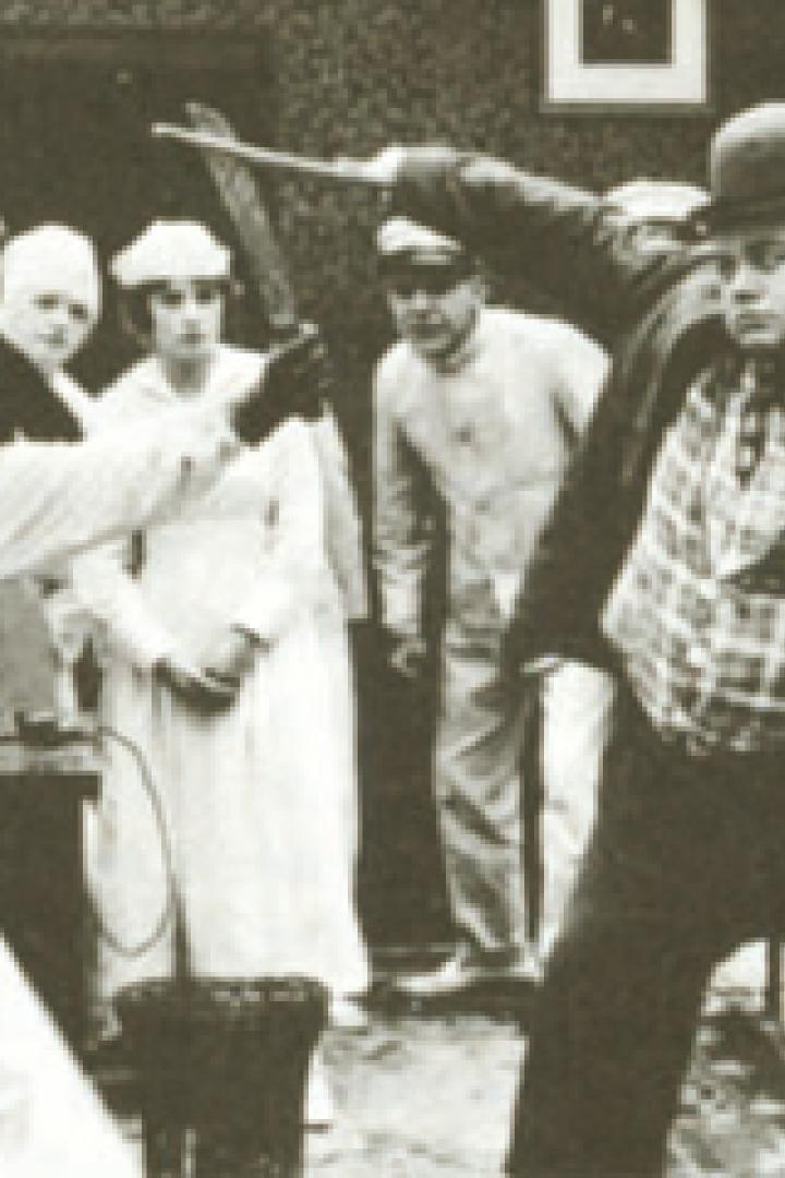Szene mit Roscoe „Fatty“ Arbuckle, der in einem Film mit einem Kochmesser bedroht wird.