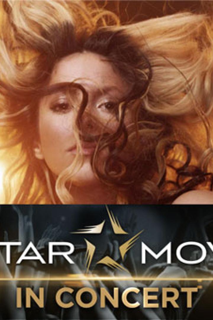 Eine Frau mit blonden Haaren vor einem goldenen Hintergrund und einem Mikrofon für „Star Movie in Concert“.