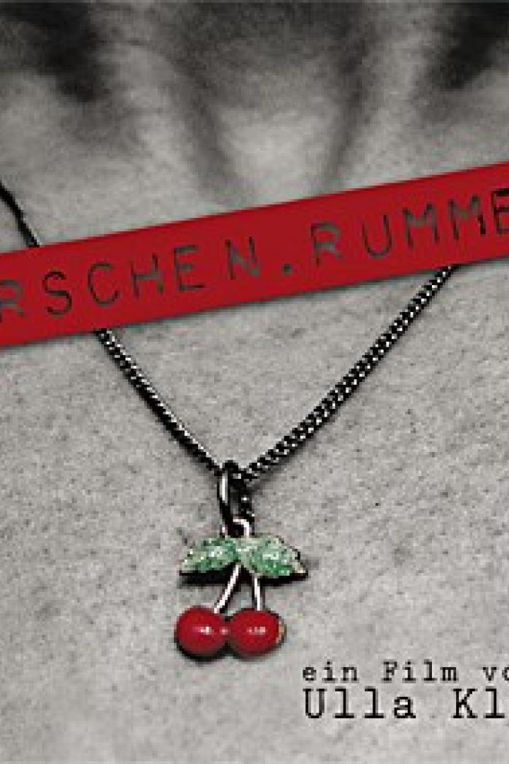 Das Filmplakat von „Kirschenrummel“ zeigt eine Nahaufnahme einer Halskette mit Kirschenanhänger.