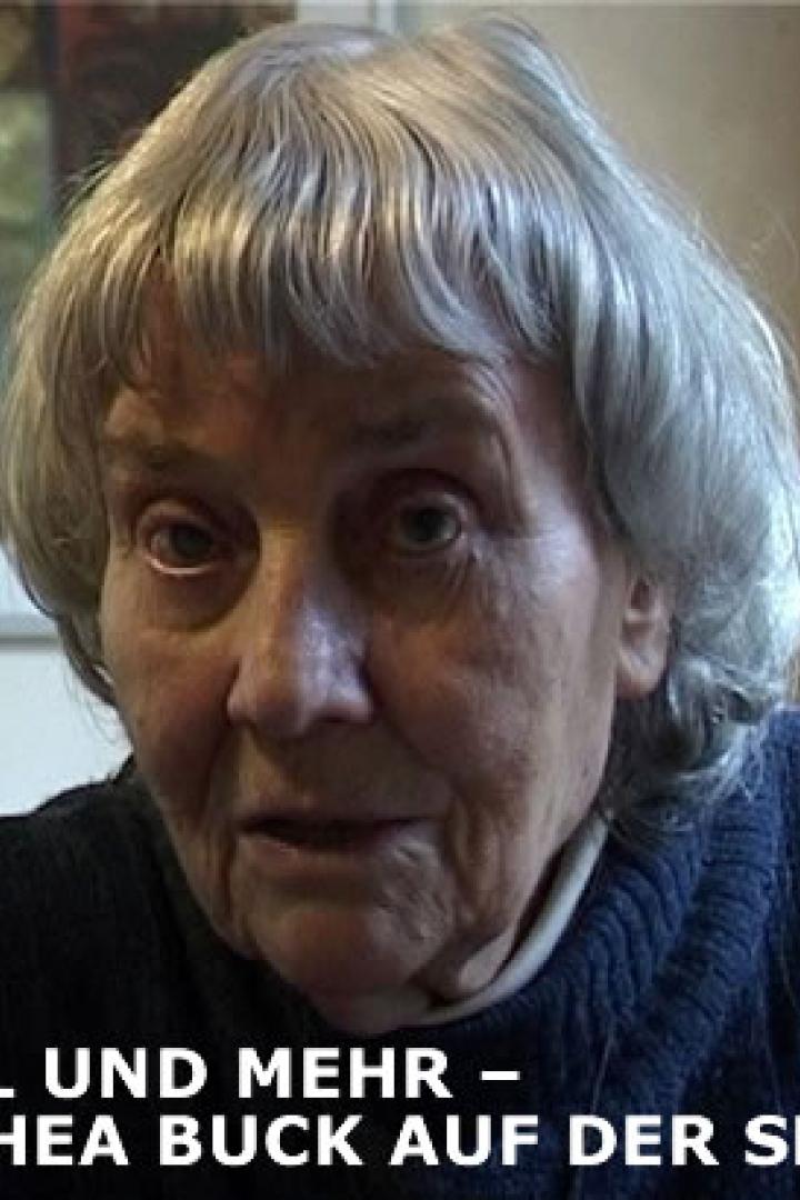 Eine ältere Frau mit grauen Haaren schaut in die Kamera.