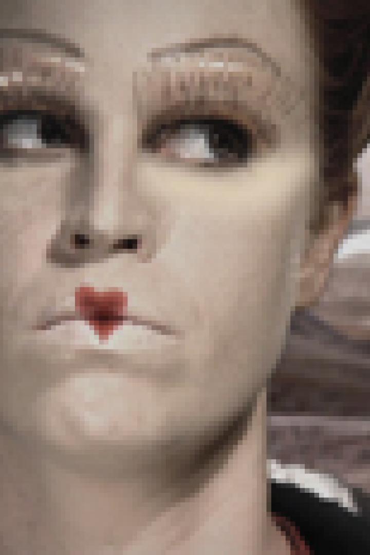 Eine Frau mit starkem Make-up und einem roten Herz auf den Lippen blickt zur Seite.