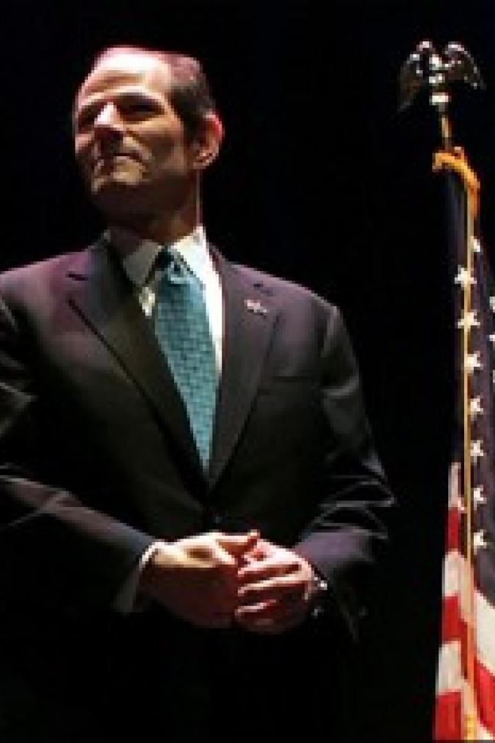 Eliot Spitzer steht vor einer US-Flagge.