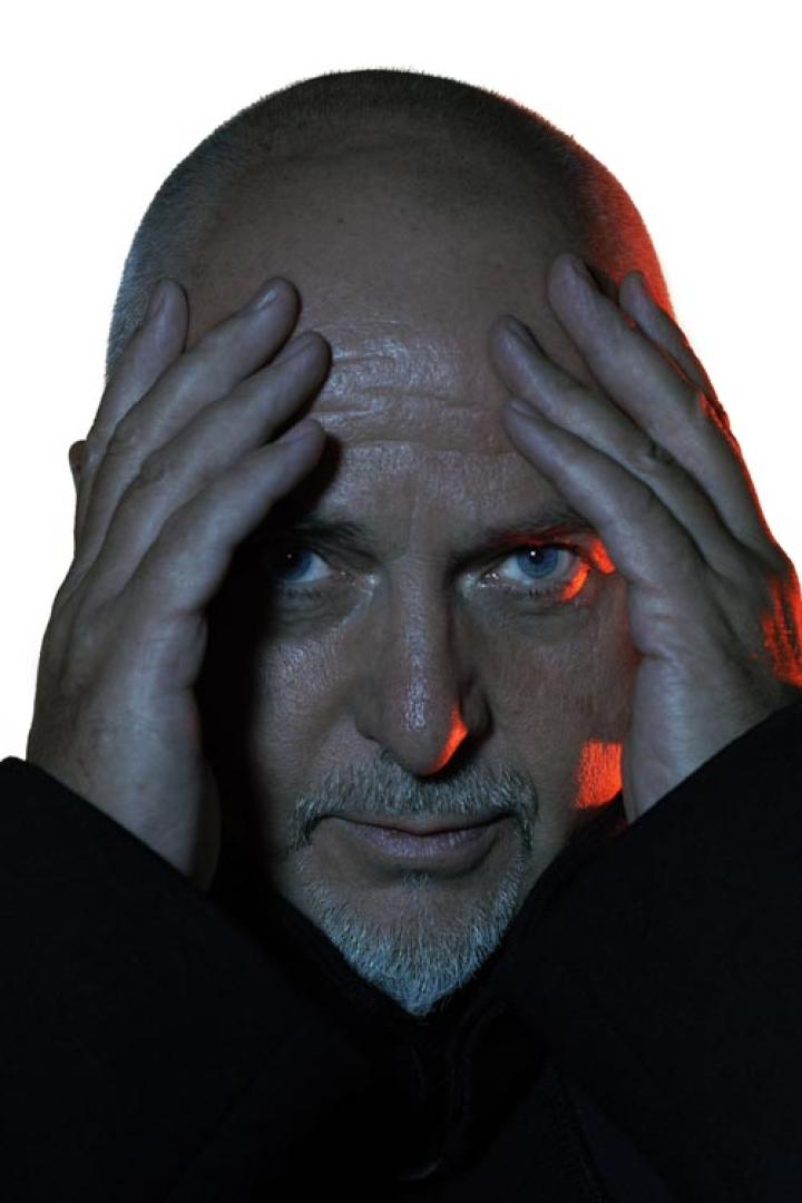 Porträt von Peter Gabriel mit den Händen an der Stirn.