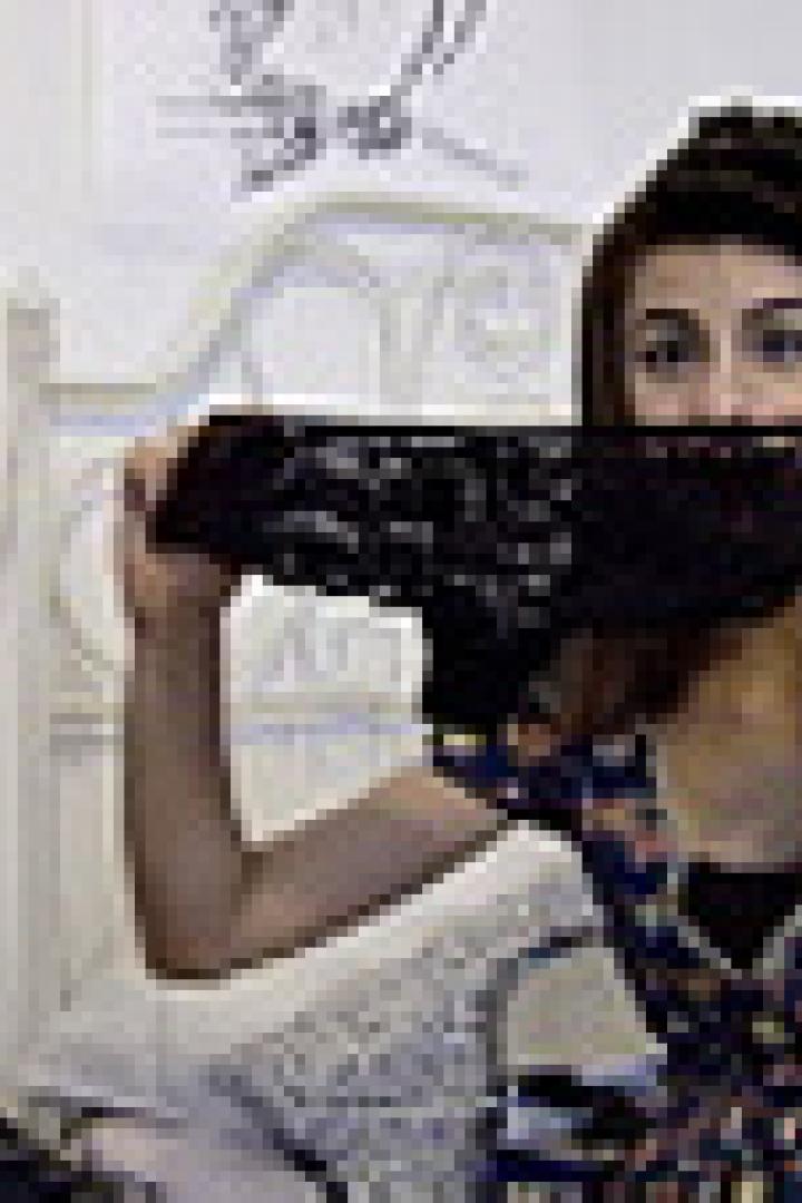 Eine junge Frau hält eine schwarze Spitzenunterhose vor ihr Gesicht.