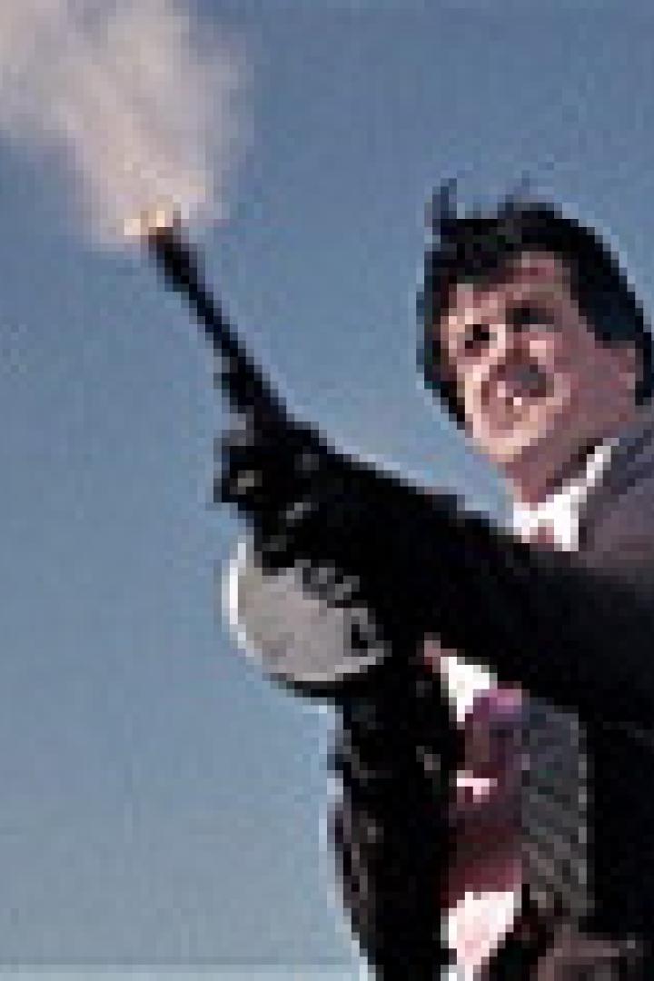 Sylvester Stallone feuert in einem Film mit einer Thompson-Maschinenpistole in den Himmel.
