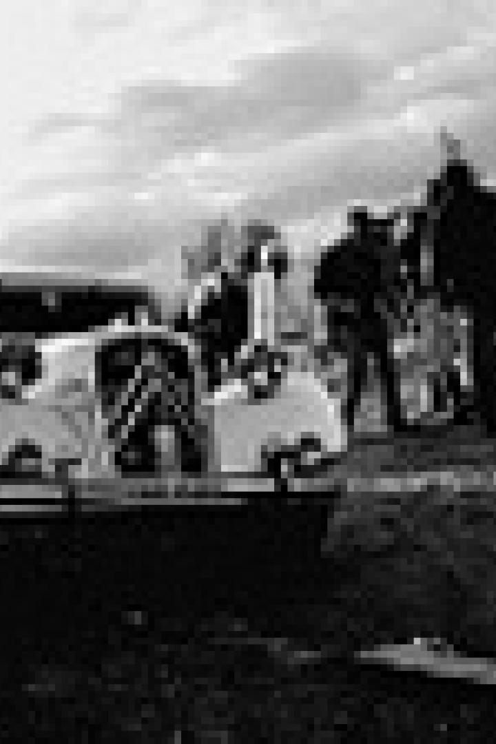 Ein Citroën Traction Avant steht auf einer Anhöhe, umringt von Menschen.