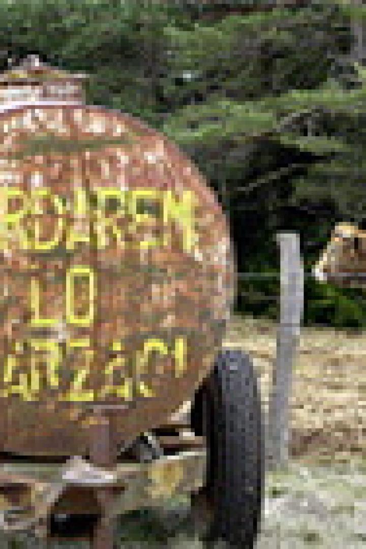 Ein rostiger Tankwagen mit der Aufschrift „Gardaren Lo Larzac“ steht auf einer Wiese.