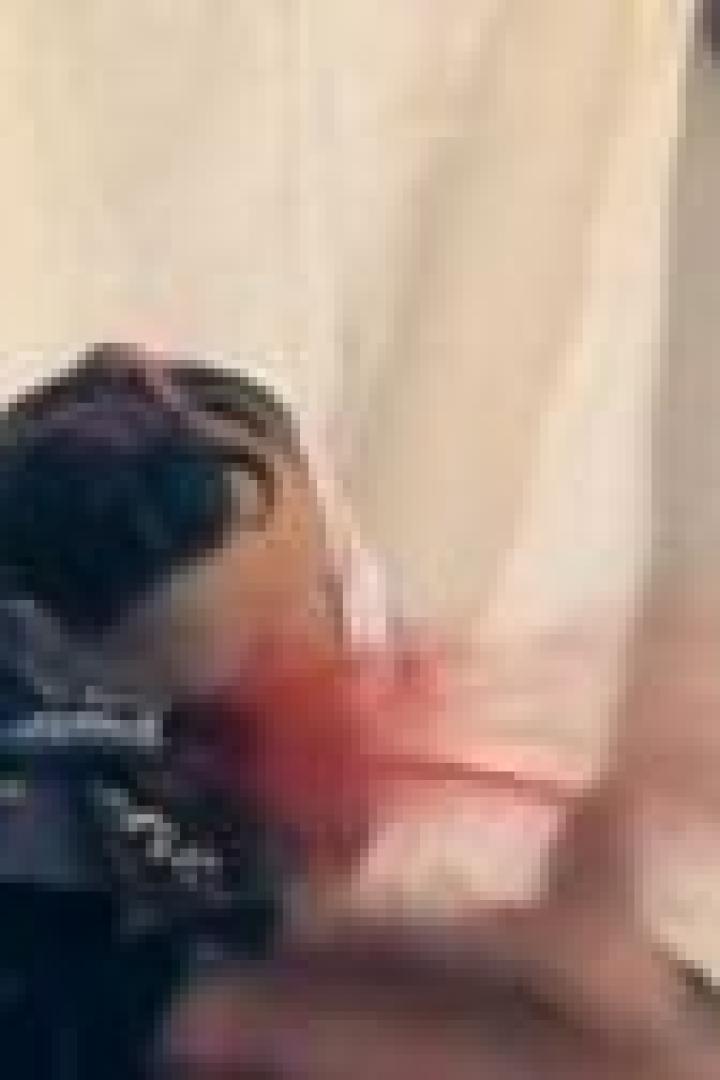 Ein Mann rasiert den Hals einer anderen Person mit einem Rasiermesser.