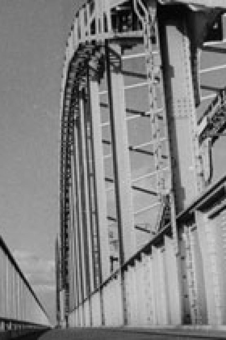 Eine Schwarzweißaufnahme einer Stahlbrücke mit vielen Nieten.