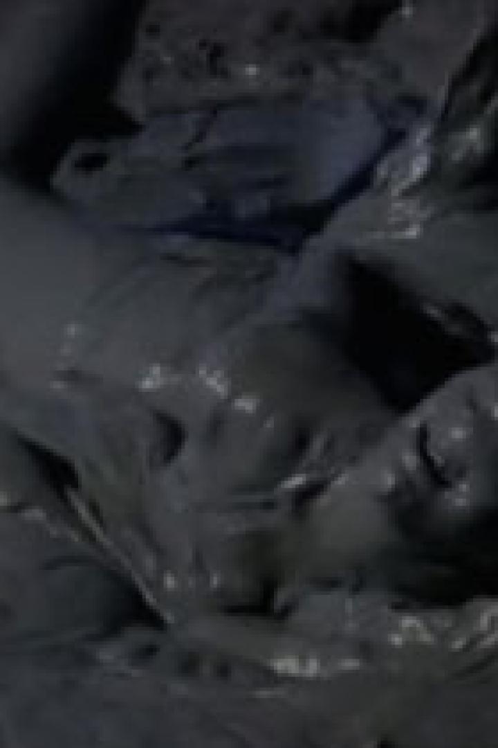 Eine Person liegt vollständig mit Schlamm bedeckt im Schlamm.