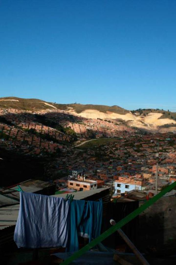 Blick über eine dicht bebaute Stadtlandschaft in einem Tal, im Vordergrund Wäscheleinen.