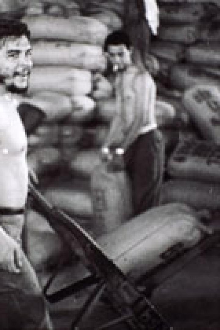 Che Guevara bei der Arbeit in einem Lagerhaus mit anderen Männern.