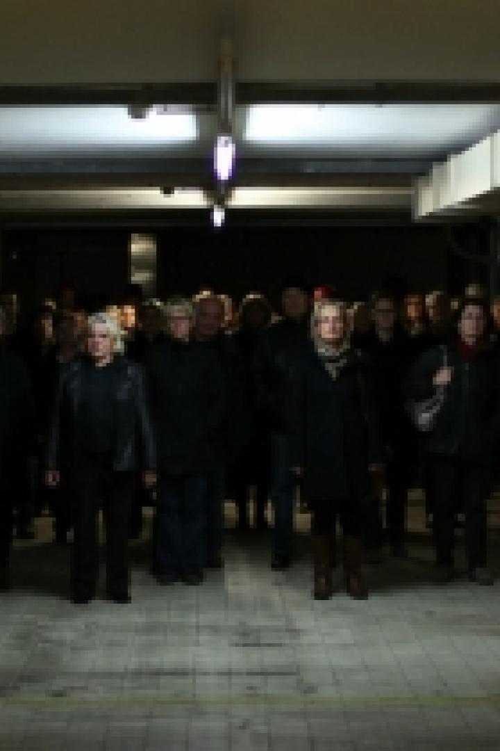 Eine Gruppe von Menschen steht in einem schlecht beleuchteten Gang.