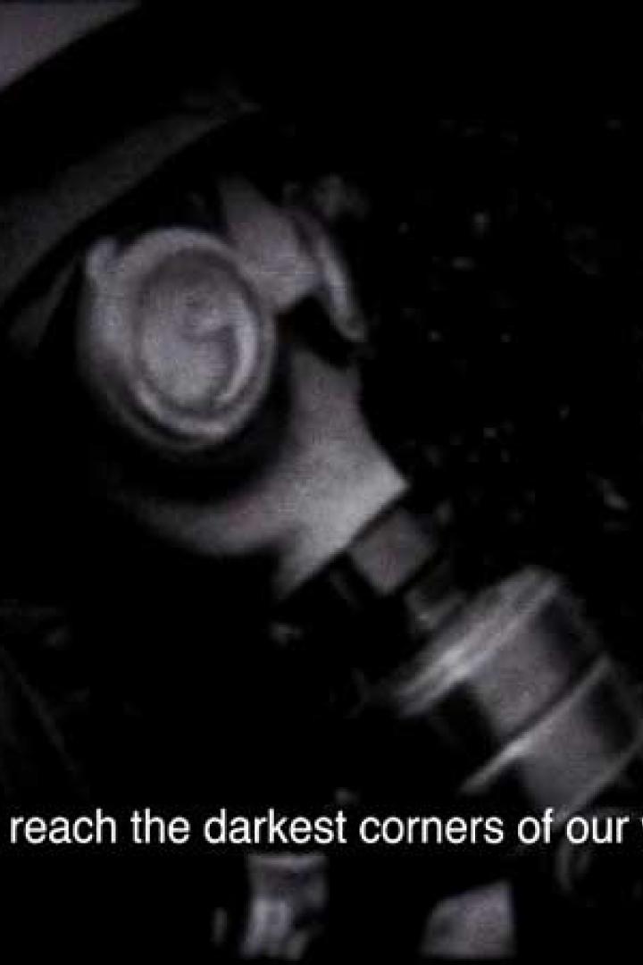 Eine Person trägt in einer dunklen Umgebung eine Gasmaske.