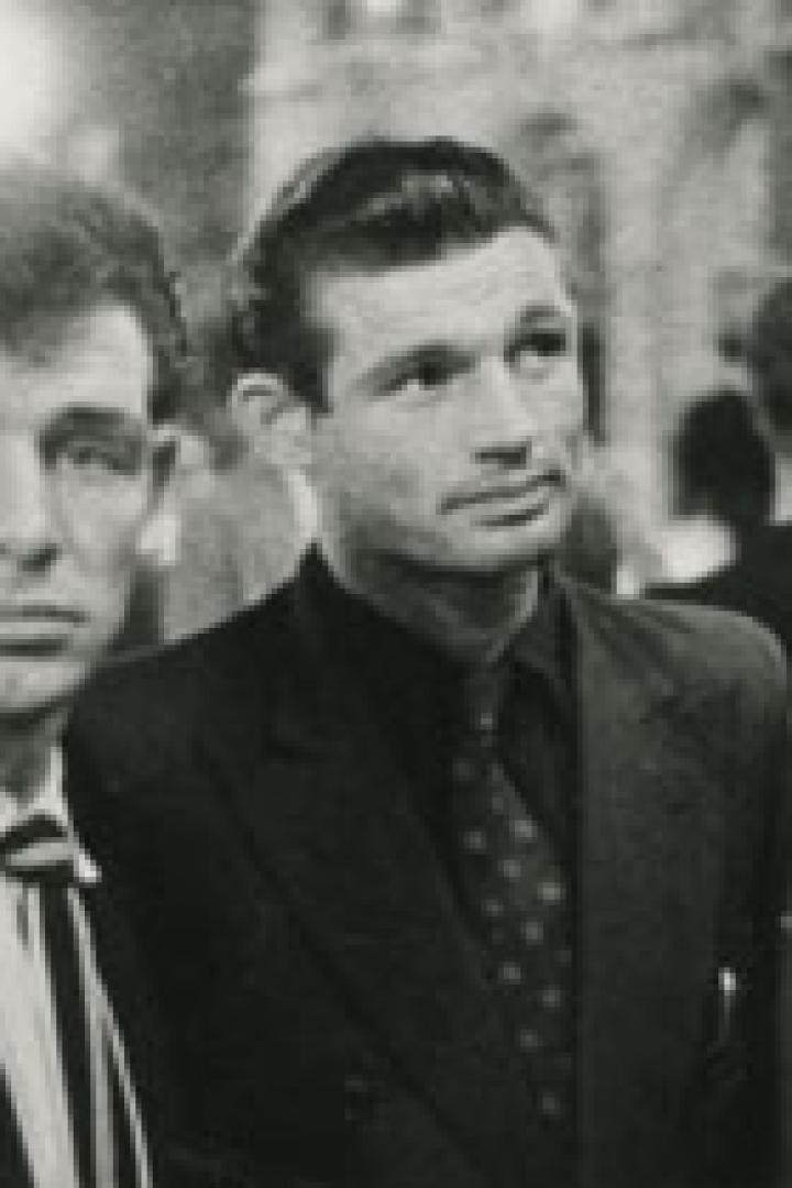 Zwei Männer in Anzügen stehen zusammen und schauen in die Ferne.