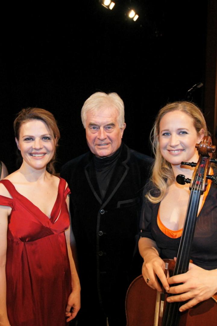 Fünf Musikerinnen und ein Dirigent posieren mit ihren Instrumenten.