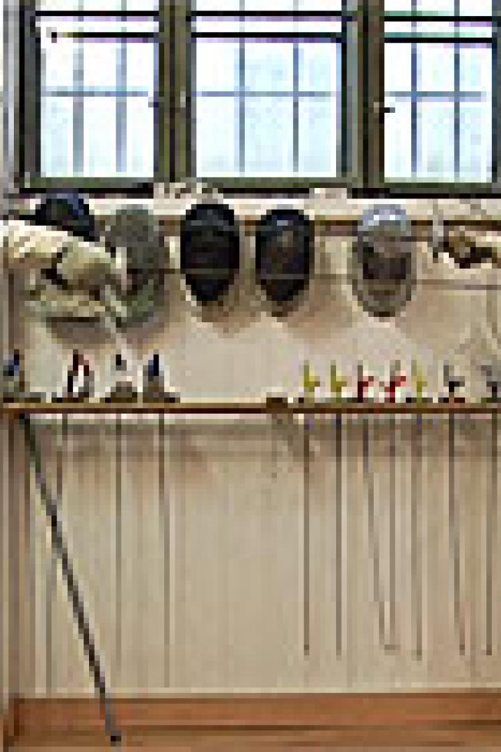 Zwei Fechter stehen sich mit Masken und Degen gegenüber.