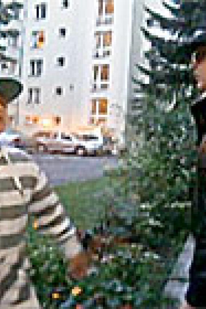 Ein Junge und ein Mädchen unterhalten sich vor einem Wohnhaus.