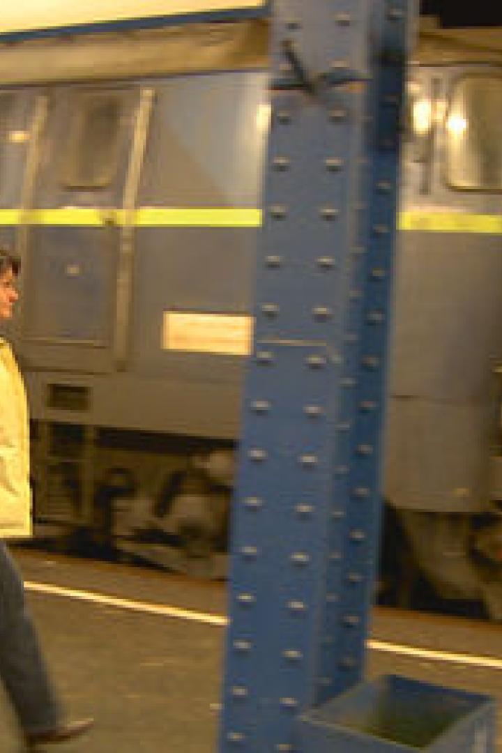 Eine Frau geht an einem Güterzug vorbei.