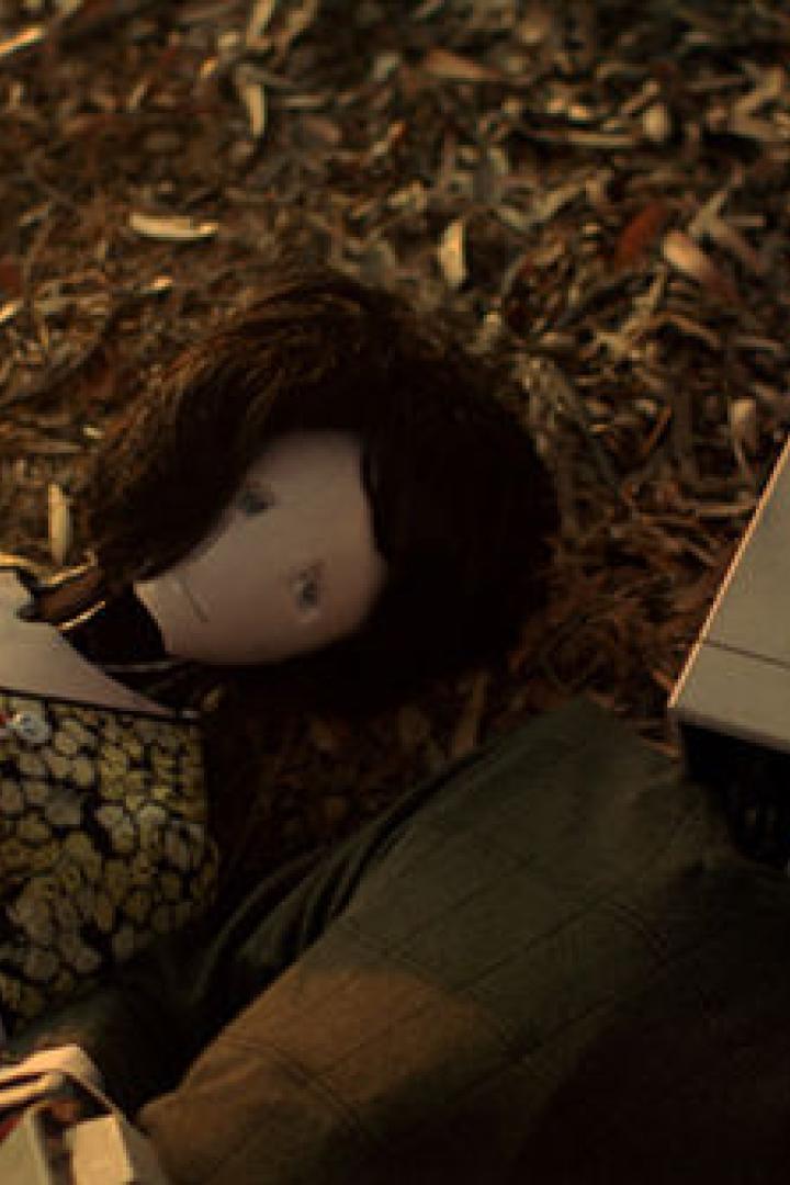 Eine Stoffpuppe und ein alter Computer liegen auf dem Boden.