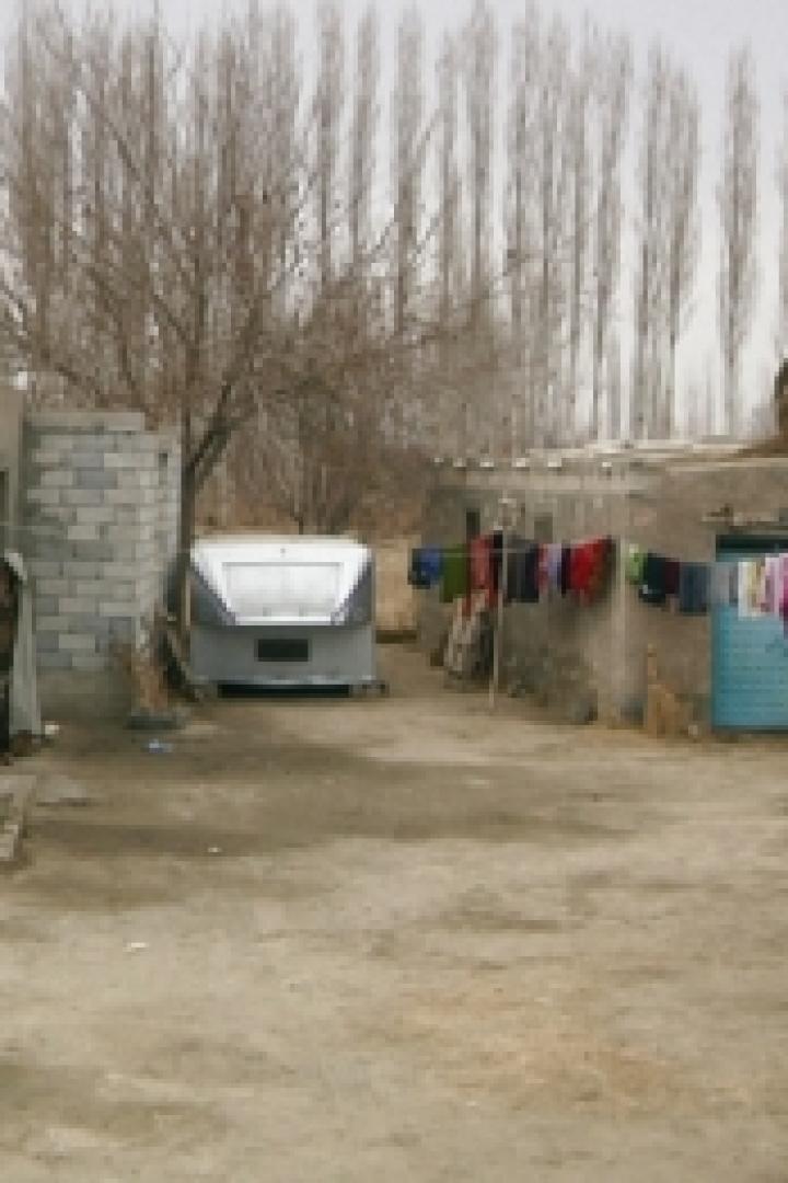 Eine ländliche Szene mit einfachen Häusern und Wäscheleine im Hof.