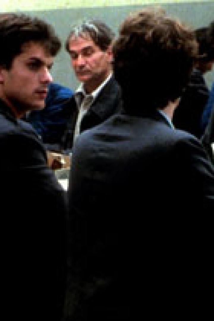 Mehrere Männer sitzen an einem Tisch und unterhalten sich.