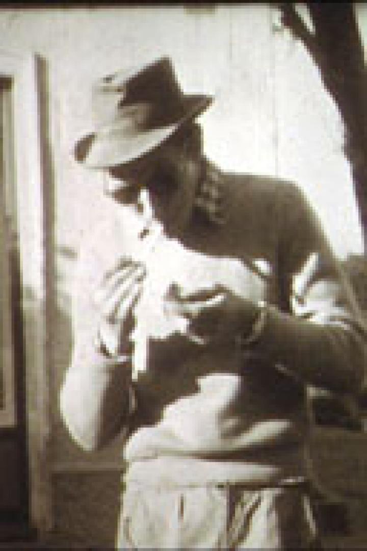 Ein Mann mit Hut und Sonnenbrille dreht sich eine Zigarette.