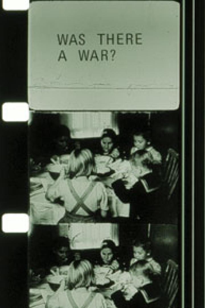 Ein Filmstreifen zeigt eine Gruppe von Kindern, die an einem Tisch essen, überlagert mit der Frage „Was gab es einen Krieg?“.