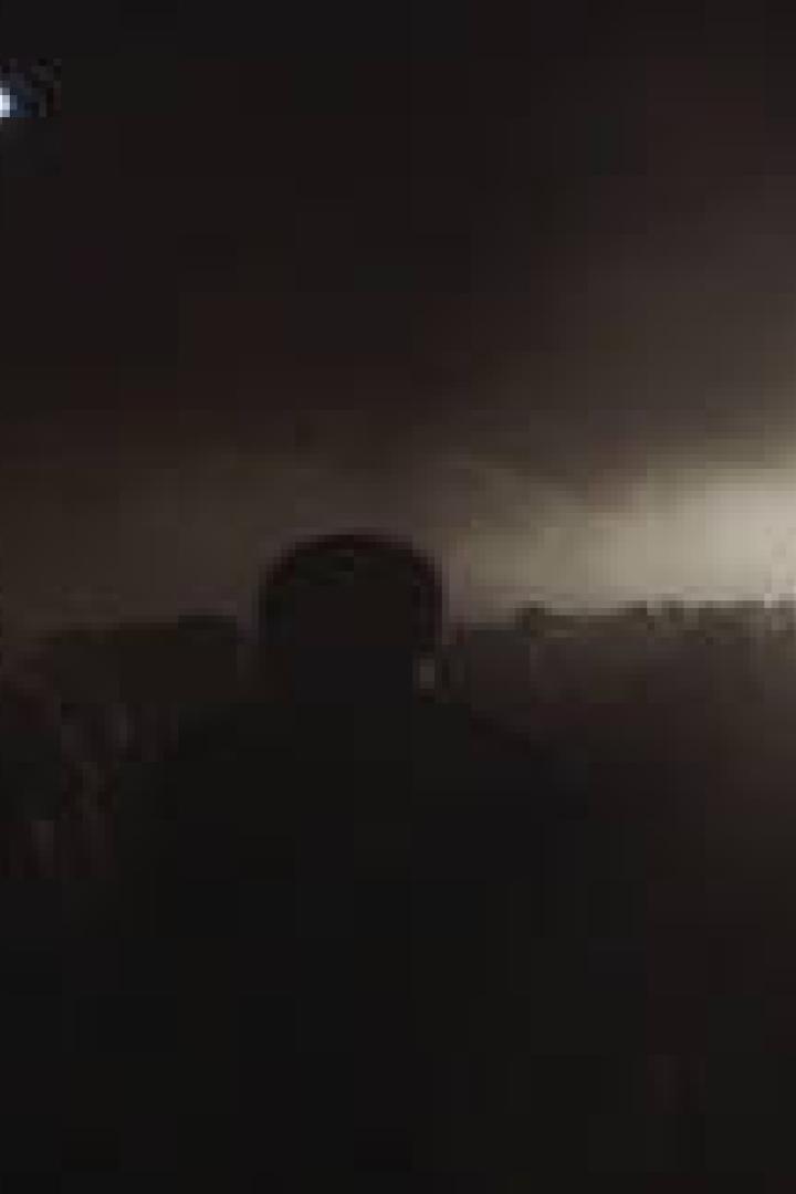 Eine Menschenmenge steht im Dunkeln vor einem hell erleuchteten Gebäude.