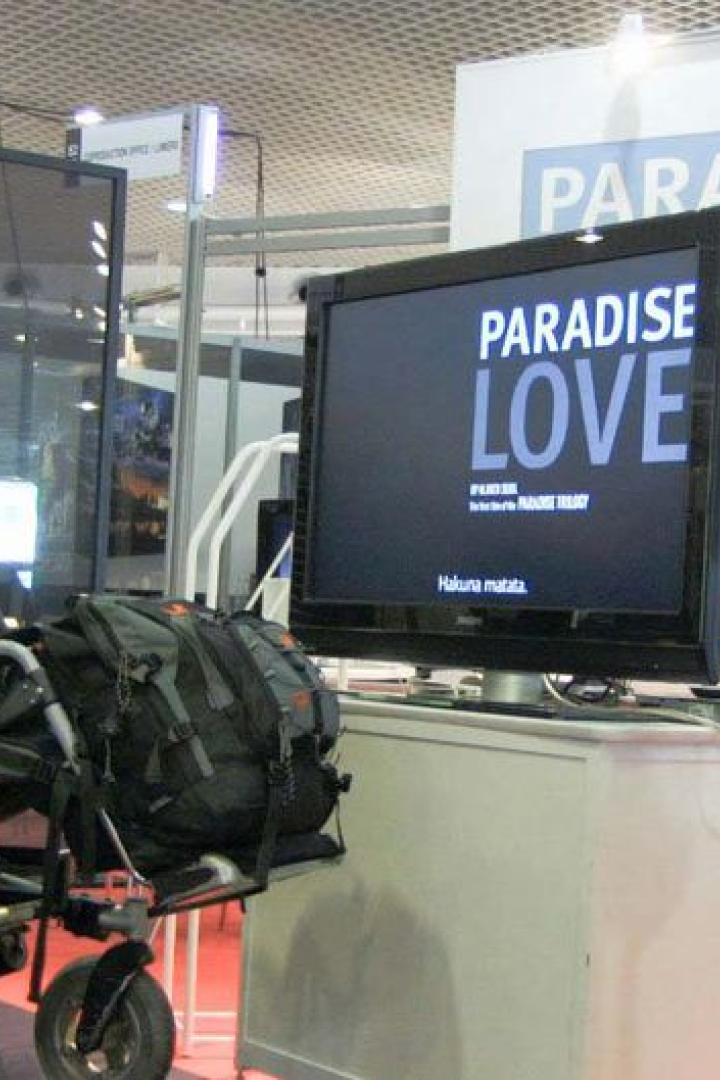 Ein Mann im Rollstuhl schaut sich den Filmtitel „Paradise Love“ auf einem Bildschirm an.