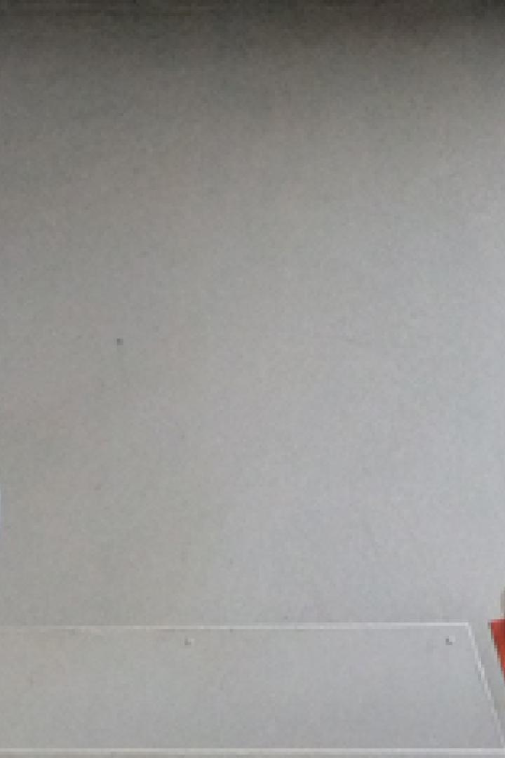 Ein Mann mit Bart und Brille steht auf einer Treppe vor einem Gebäude.