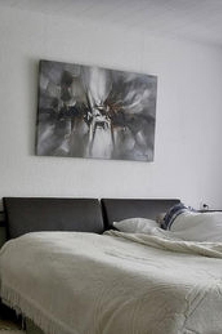 Ein Schlafzimmer mit einem Gewehr an der Wand neben dem Bett.